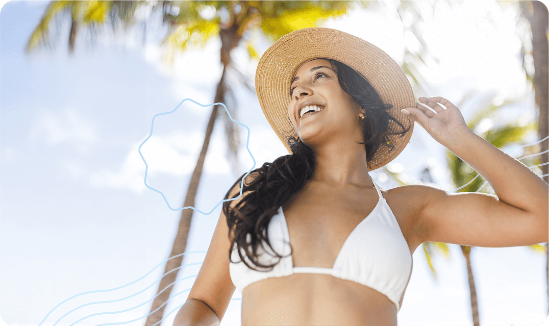 Woman in a white hat and a white bikini holding her hat