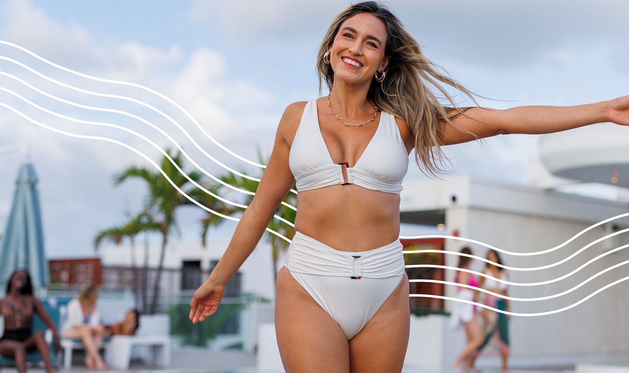 Woman in a white bikini standing on a pool deck and holding her arms up for a piece titled full body laser hair removal
