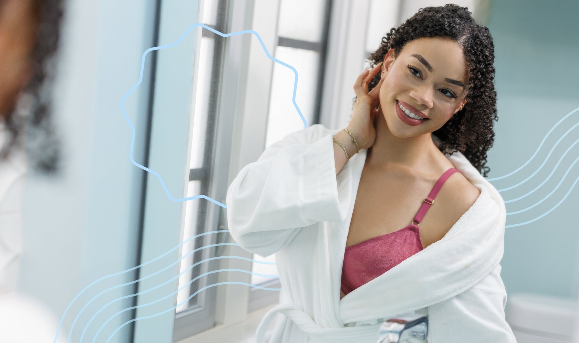 Woman smiling and looking into the mirror while holding her hand up to her face, brimming with confidence after getting face laser hair removal