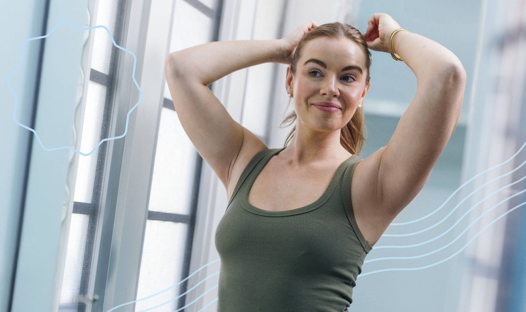 Woman holding her arms above her head and standing in front of a mirror after learning how to prepare for laser hair removal